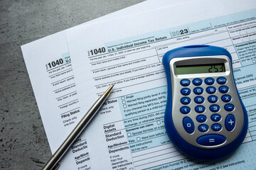 Tax deduction planning 1040 tax forms with calculator pen at office desk