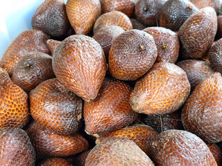 Collection of fresh salak fruit at a traditional Indonesian market.  The dark brown color of snake fruit skin creates a tempting and healthy appearance, a tropical fruit delicacy.