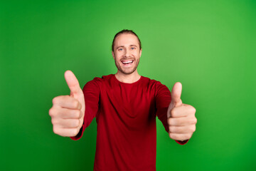 Photo of satisfied man with stubble dressed red pullover showing you thumbs up approve good work...