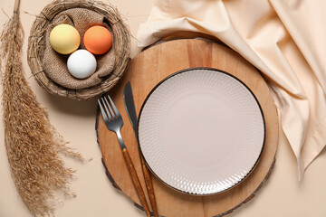 Beautiful table setting for Easter with eggs and dry reeds on beige background