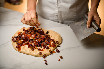 Cook kneads dried fruit into dough, a delightful preparation