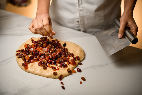 Cook kneads dried fruit into dough, a delightful preparation