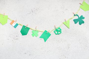 Paper garland with clover and Irish flag for St. Patrick's Day celebration on white background