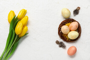 Fototapeta na wymiar Nest with painted Easter eggs and tulip flowers on white background