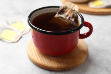 Brewing tea. Cup with tea bag on light table, closeup