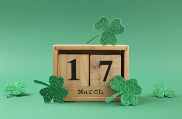 St. Patrick's day - 17th of March. Block calendar and decorative clover leaves on green background