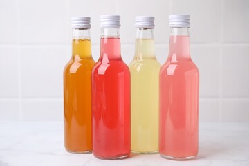 Delicious kombucha in glass bottles on white marble table