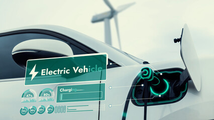 Electric car recharging energy from EV charging station display futuristic smart battery status hologram by EV charger plug cable in wind turbine farm. Alternative clean energy sustainability. Peruse
