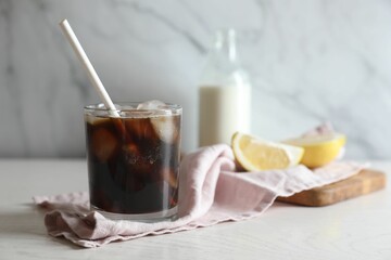 Refreshing iced coffee in glass on white wooden table