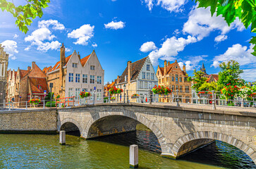 Carmelite Bridge, Langerei water canal of Reie river, stone arch bridge and medieval buildings on embankment in Brugge old town quarter, Bruges city historical centre, Flemish Region, Belgium - obrazy, fototapety, plakaty