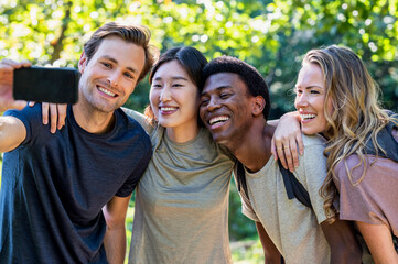 Young adult man taking a selfie with friends during hiking excursion