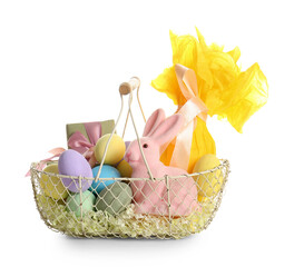 Basket with painted Easter eggs, toy bunny and gift box on white background