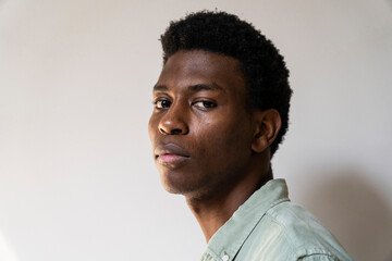 Obraz premium Side view portrait of young adult man looking to the camera