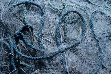 Bunch of abandoned fishing nets and ropes lying around on pier - obrazy, fototapety, plakaty