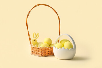 Baskets with painted Easter eggs and toy bunny on yellow background