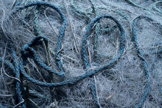 Bunch of abandoned fishing nets and ropes lying around on pier