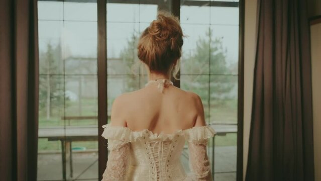 Young sexy woman walking in classic room go to window waiting love. Fairy tale princess bride adult girl beauty back rear view. royal home white vintage dress long ball gown old style blonde hair. 4k