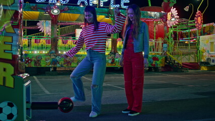 Teenage girls having fun at amusement luna park. Joyful happy female hit ball 