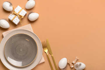 Festive Easter table setting with eggs and gifts on beige background