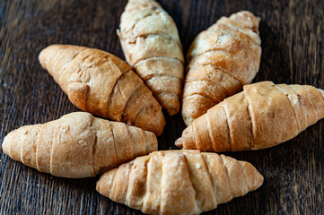 six homemade croissants arranged on a wooden surface. top view
