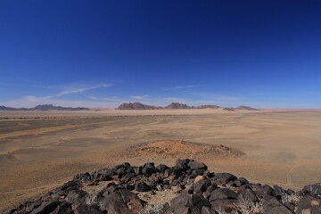 namib desert sand landscape with black rocks