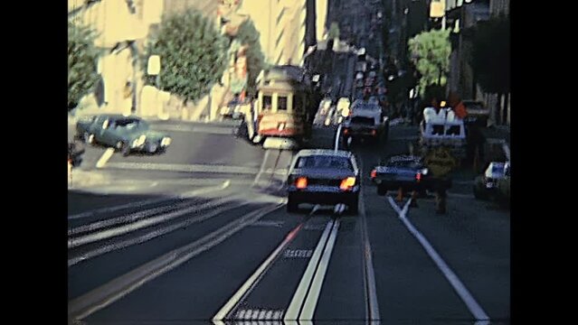 San Francisco, United States - in 1980: Restored archival footage in the 1980s of the red cable car in San Francisco California street with Bay bridge in the background.