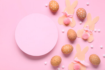 Easter eggs, paper bunnies and  pink blank card on pink background. Top view