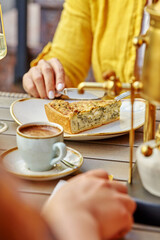 Woman enjoying savory quiche with coffe in cafe