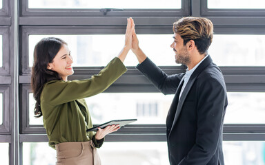 Caucasian smart businessman and woman wearing formal clothes, smiling with happiness, confidence, success, achieve target or goal, high five, tag hands, holding tablet. Entrepreneur, Business Concept.