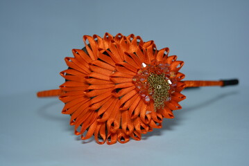 Women's interesting hair decoration, festive look. Beautiful fabric head hoop made of orange glossy...