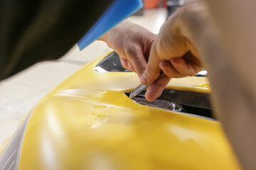 Car wrapping. A car wrapping specialist applies a polyurethane film to the car. Selective focus....