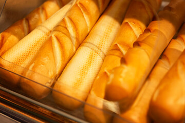 Appetizing fresh baguettes on the counter. Traditional breakfast pastries. Close-up.