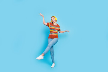 Fototapeta na wymiar Full size photo of carefree adorable woman dressed knit t-shirt dancing in headphones having fun isolated on blue color background