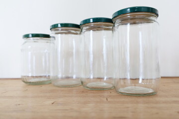 multiple transparent empty glass jars on wooden counter