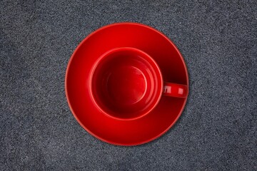 Red cup for morning coffee on desk background.