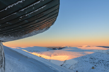 Winter, sunrise time,  roof of disc shaped meteorological observatory in snezka, mountain on the...