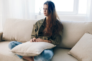 Worried Woman Sitting on a Couch, Feeling Sad and Stressed - Depicting Mental Health Troubles in Home Setting