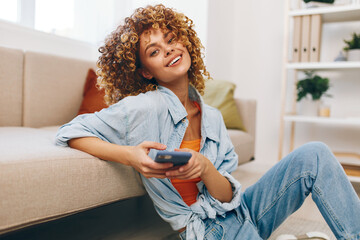 Smiling Woman Holding Mobile Phone on Cozy Sofa in Living Room