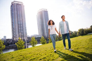 Photo of young happy couple lovers beautiful idyllic family stroll holding arms together at garden backyard modern residential complex