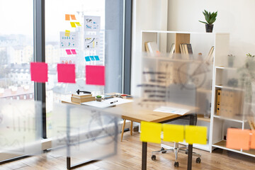 Modern bright office with transparent flip chart with stickers graphs and charts. Place of work of business team of economic development analysts.