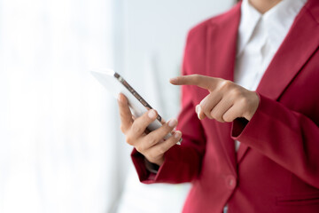 Smiling businesswoman using a smartphone in a corporate setting. Mobile technology in business and communication concept.
