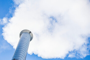 Metal chimney of a geothermal power station with stainless steel pipe structure with smoke and steam