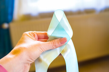 Woman hand holding Light blue, sky blue ribbons, Prostate Cancer Awareness - Powered by Adobe