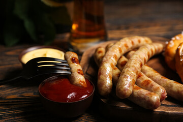 Board of tasty Bavarian sausages with sauces on wooden background. Oktoberfest celebration