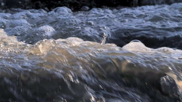 Water flow under the dam in spring winter on a sunny day, Halistenkoski, Turku, Finland