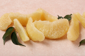 Sweet pomelo fruit pieces with leaves on pink grunge background
