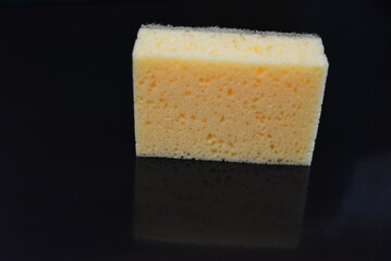 Things that are often used in the household. Colored washcloths for washing dishes are arranged on a glossy black background.