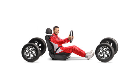 Racer in a car seat holding a steering wheel and smiling at camera