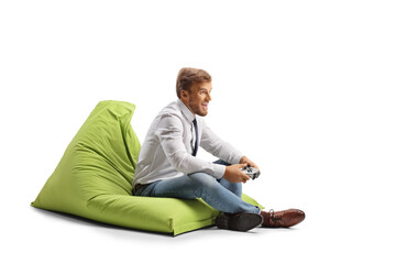 Businessman seated in a beanbag armchair playing football video game with joystick