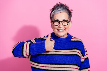 Portrait of satisfied funny pensioner woman wear striped pullover showing thumb up approve good work isolated on pink color background